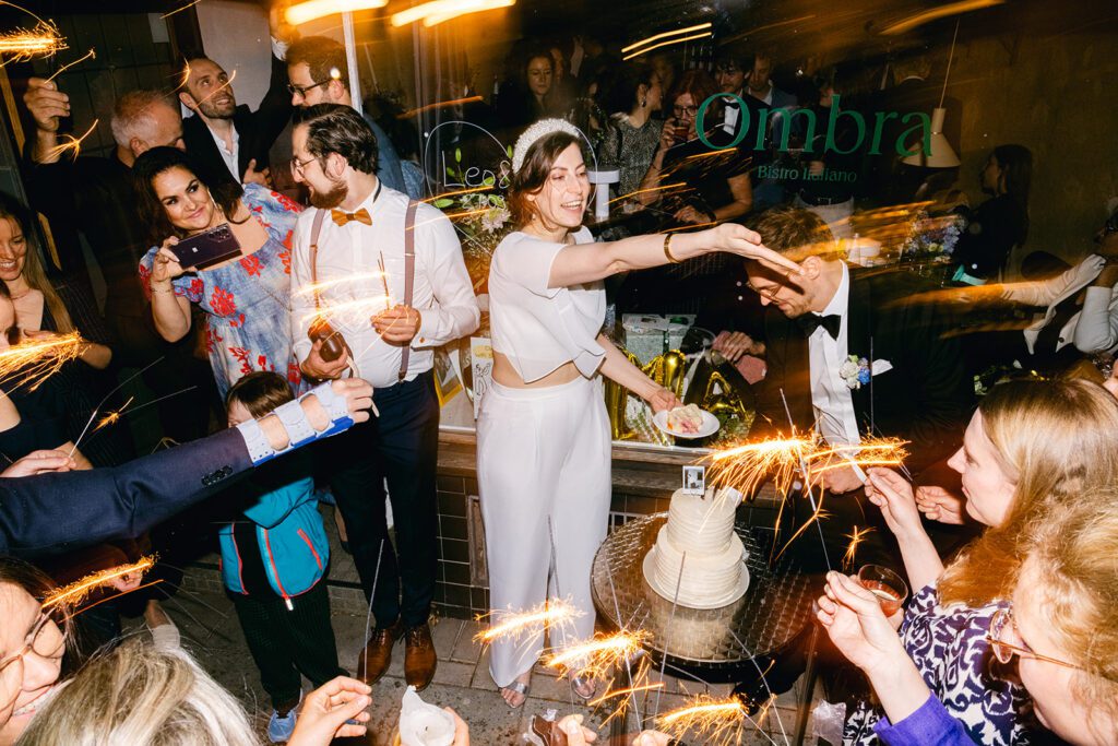 Die Braut vertielt Torten Stücke an ihre Gäste und sieht dabei sehr glücklich aus