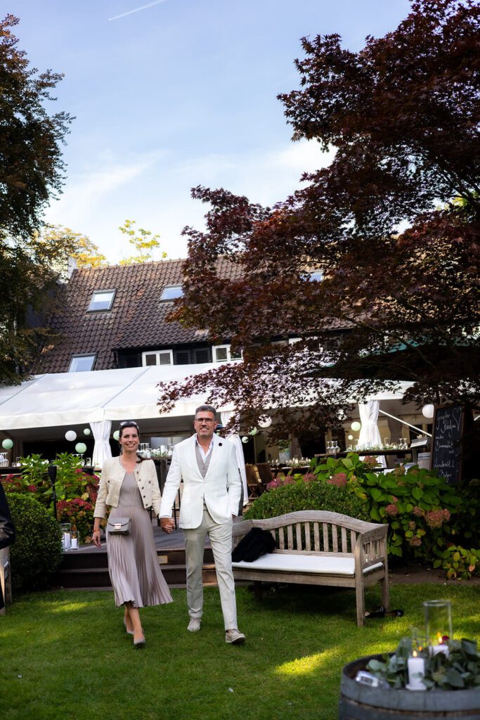 Best-Ager-Brautpaar beim entspannten Spaziergang im Garten.