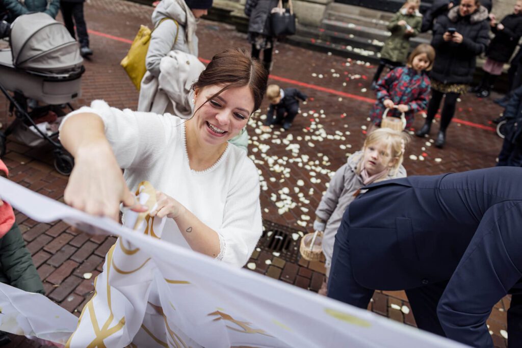 Braut muss ein Spiel spielen nach ihrer standesamtlichen Hochzeit in Hannover im alten Rathaus. Fotografier vom Fotografen Filipp Romanovski aus Hannover