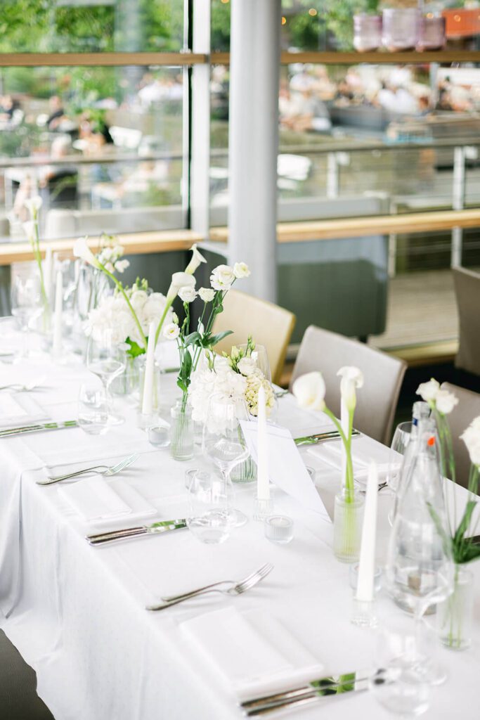 Detailaufnahme der Tischdekoration im Pier 51 in Hannover mit vielen Blumen und minimalistischen Elementen.