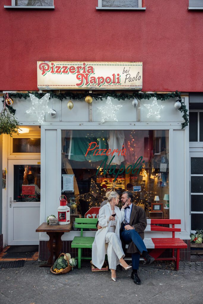 Brautpaar sitzt entspannt auf der Bank vor der Pizzeria Napoli in Hannover Linden