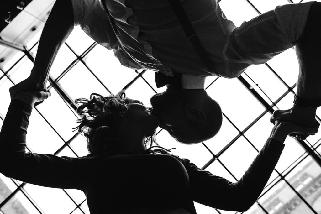 Brautpaar küsst sich und hält sich an den Händen. Aufgenommen im Atrium des alten Rathaus in Hannover vom Hochzeitsfotografen