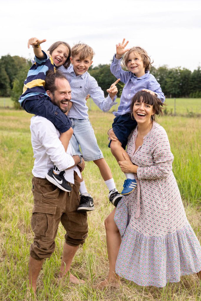 Ein Foto von einer fröhlichen Familie im Feld fotografiert auf natürliche Art und Weise.