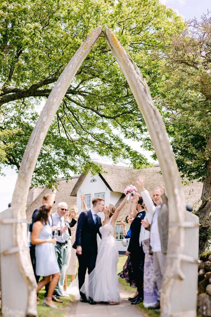 Hochzeitsgesellschaft genießt Drinks mit Blick auf das Wattenmeer nach der Trauung und feiert das Brautpaar vor dem Standesamt in Sylt